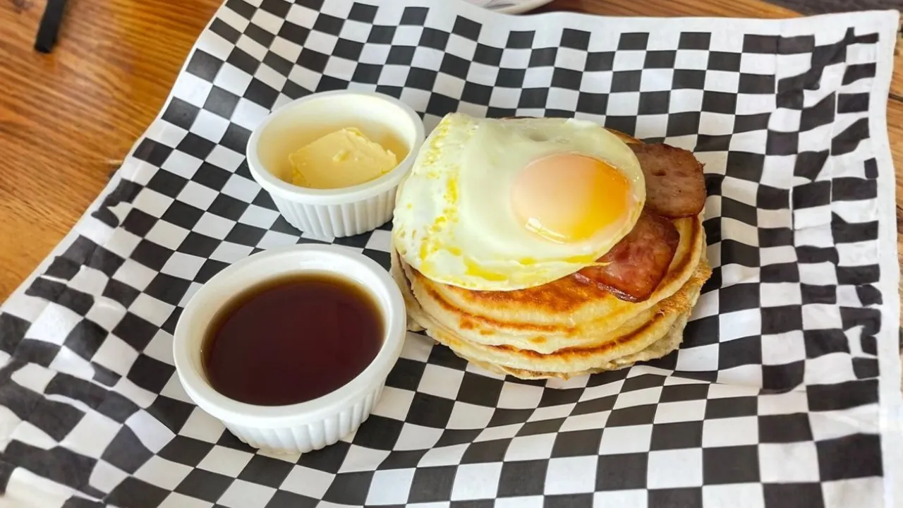 Pancakes with egg, sausage, syrup, and butter in Breakfast Menu