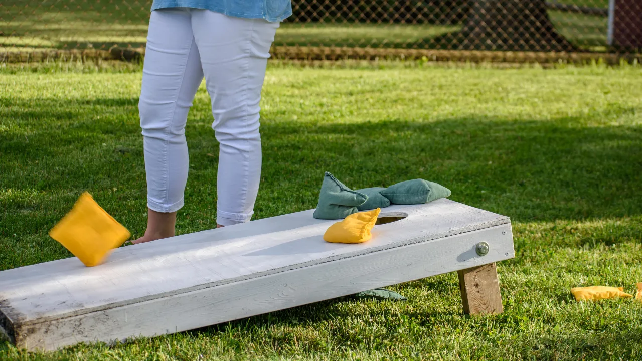 Playing Cornhole with yellow and green beanbags around best food trucks Austin loves
